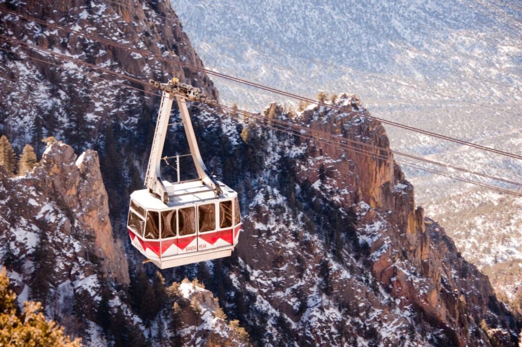 The red gondola on the sandia peak tramway makes it way to the Sandia Crest.